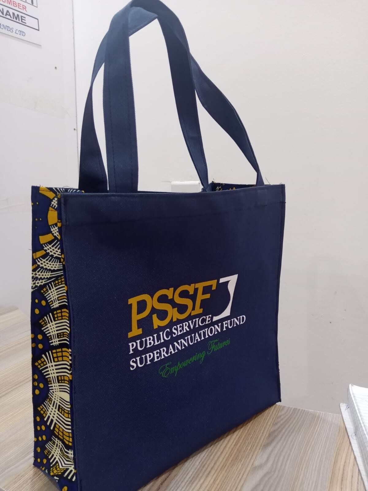 Navy blue PSSF branded tote bag with Ankara print trim